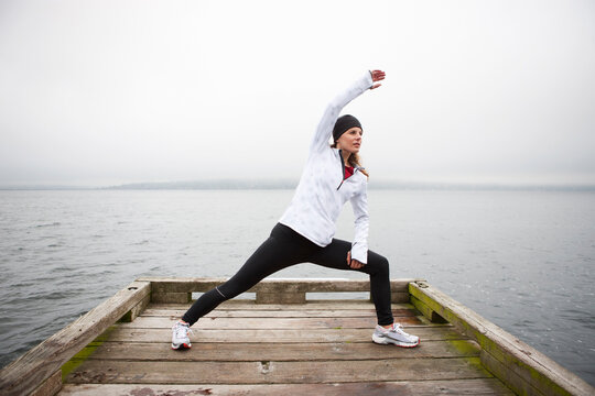 Woman Stretching on Dock before Jogging, Puget Sound, Seattle, Washington, USA