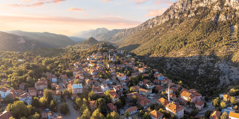From above, turkish Ormana village colorful houses and vibrant gardens create a striking contrast against the rugged Taurus mountain terrain.
