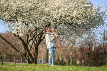 Young mother and her cute daughter having a fun in spring time park in Prague, Europe