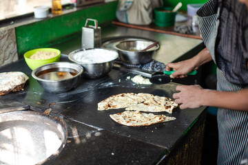 Unrecognizable man cooks food on kitchen metal surface. Dishes and kitchen equipment. Cooking. Professional activity. 