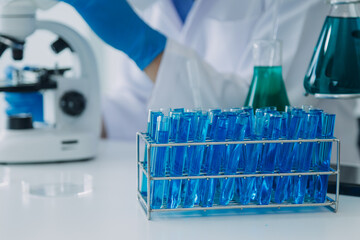 biochemical research scientist team working with microscope for coronavirus vaccine development in pharmaceutical research labolatory, selective focus