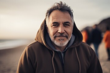 Portrait of senior man with grey beard looking at camera on the beach.