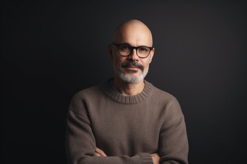 Obraz premium Portrait of a bald man with glasses on a black background.