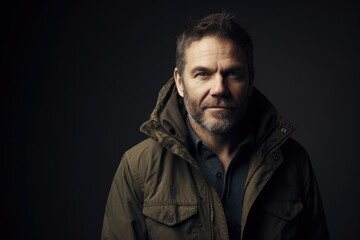 Portrait of a handsome mature man in a jacket on a dark background