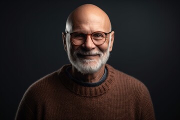 Obraz premium Portrait of an old man with glasses on a dark background.