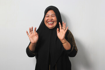 Funny Middle aged Asian women wearing hijab laughing hard with big open mouth