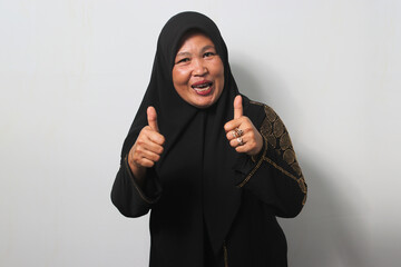Cheerful Middle aged Asian women wearing hijab shows thumbs up gesture, give positive review