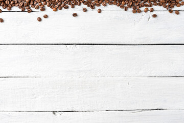 Aromatic coffee beans on white wooden table. Top view