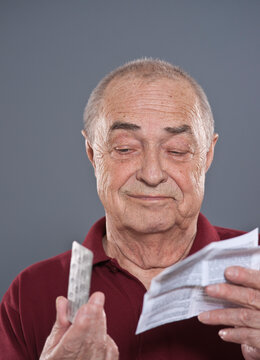 Man Looking at Blister Pack of Pills