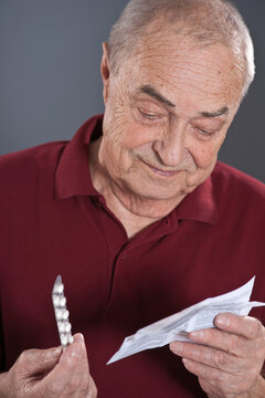 Man Looking at Blister Pack of Pills