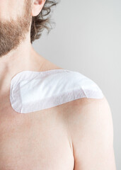man wears a large band-aid after collarbone surgery
