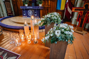 A church decorated with candles and flowers up close