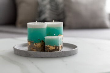 Decorative candles on a concrete base on a marble table in a room. Modern interior in the living room. Close-up. Photo