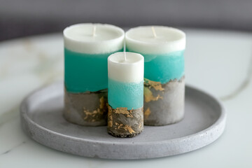 Decorative candles on a concrete base on a marble table in a room. Modern interior in the living room. Close-up. Photo