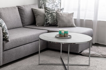 Modern interior in the living room. Decorative candles on a concrete base on a marble table in a room. Photo