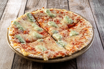 Pizza with mozzarella on a plate. The pizza is cut into 4 pieces. Fast food. Photo