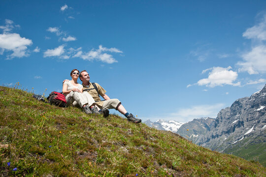 Couple Sitting on Mountain Side, Bernese Oberland, Switzerland