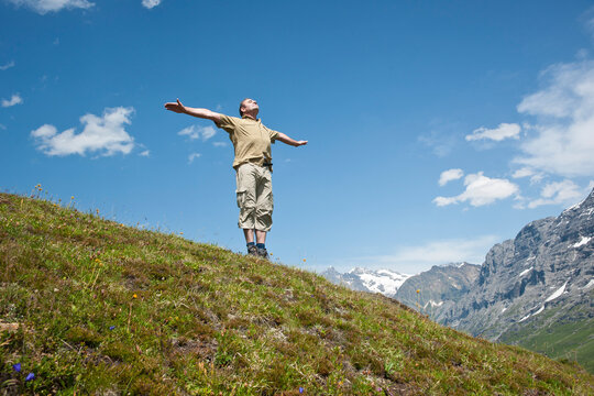 Man Standing on Mountain Side with Arms Outstretched, Bernese Oberland, Switzerland