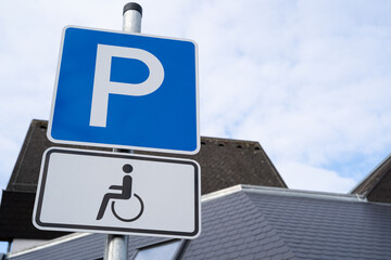 Blue and white parking sign with wheelchair for drivers with disabilities
