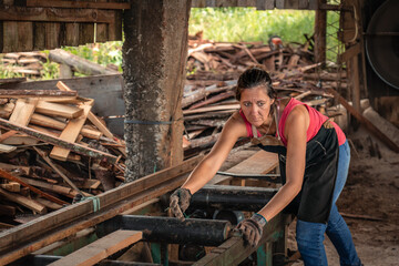 Portrait of a woman looking to the side with worried face, working in a sawmill.