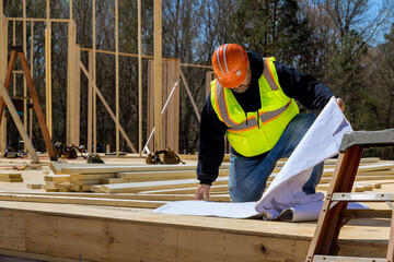 In course construction process an safety inspector checks quality of work performed on site using construction blueprints