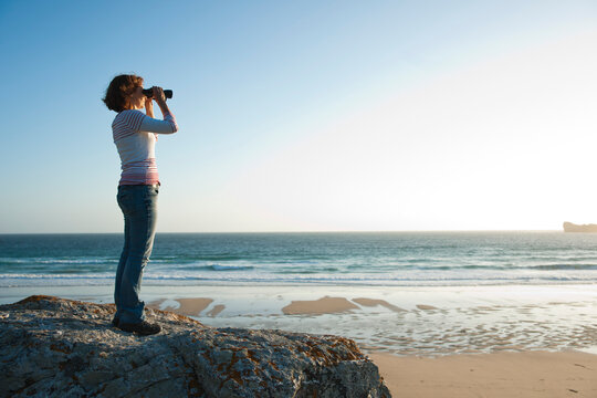 Woman Looking into the Distance Using Binoculars at the Beach, Camaret-sur-Mer, Crozon Peninsula, Finistere, Brittany, France