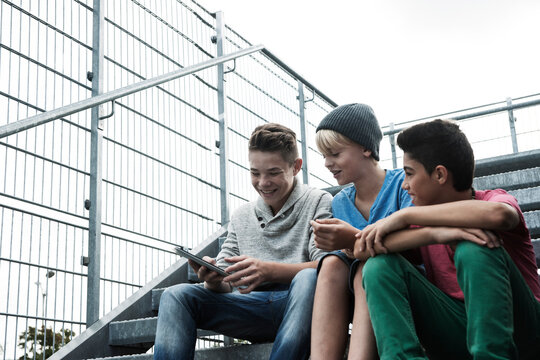 Boys with Tablet Sitting on Bleachers, Mannheim, Baden-Wurttemberg, Germany