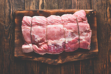 Pork loin joint on rustic cutting board