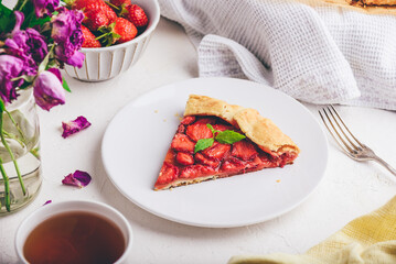 Slice Of Delicious Fresh Baked Vegan Strawberry Galette With Mint Leaves On White Ceramic Plate