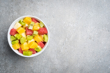 Colorful fruit salad on gray stone table. Food background - 591634620