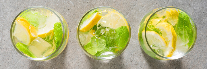 Refreshing lemonade with mint leaves and ice on gray stone table - 591634650