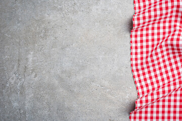 Red folded tablecloth on gray stone table. Top view - 591634803