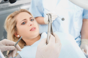 Young Woman looking at Dental Instruments during Appointment, Germany