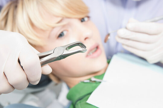 Anxious Boy looking at Dental Instruments during Appointment, Germany
