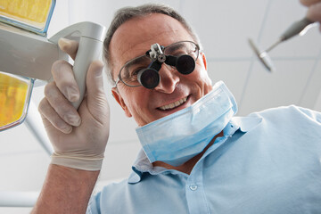 Close-up of Dentist with Magnifier on Eyeglasses in Dental Office, Germany