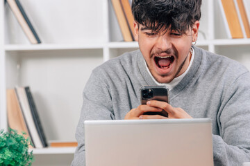 young man in with mobile phone and laptop