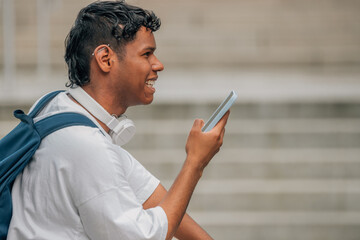 young latino man in the street with mobile phone