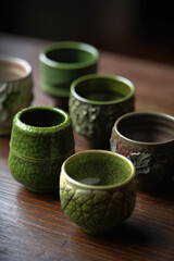 Tea cups, many green clay small cups for matcha, tea, espresso, craft. Generative AI.