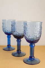 Tres copas de color azul una detrás de otra sobre una mesa.