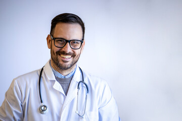 Fototapeta premium Portrait of smiling doctor with stethoscope on white background.
