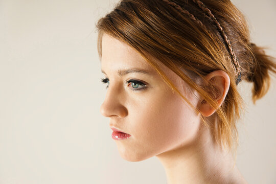 Close-up, Side View Portrait of Teenage Girl in Upsweep Hairstyle and wearing Make-up, Studio Shot on White Background