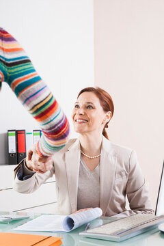 Businesswomen Shaking Hands in Office