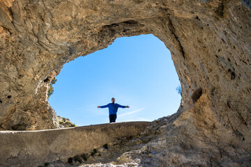 portrait of the silhouette of a boy opening his arms in the window of the devil Cuenca, Spain,