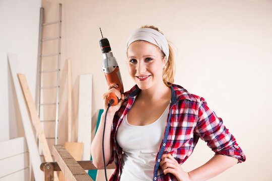 Studio Shot of Young Woman Holding Drill