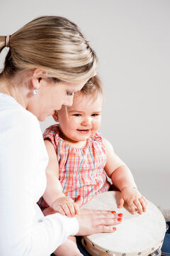 Portrait of Mother and Daughter Playing Tambourine, Studio Shot