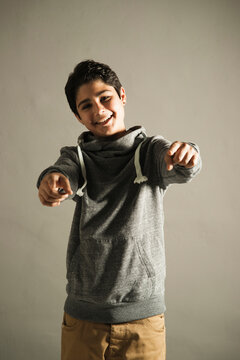 Portrait Of Teenage Boy Pointing At Camera, Studio Shot