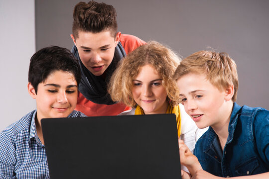 Teenagers Looking at Laptop Computer, Studio Shot