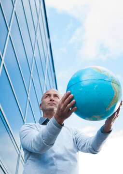 Businessman Holding Globe Outdoors, Mannheim, Baden-Wurttemberg, Germany