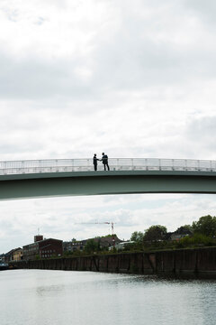 Silhouette of mature businessmen standing on bridge shaking hands, Mannheim, Germany