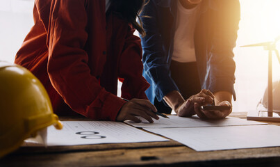 Three colleagues discussing data working and tablet, laptop with on on architectural project at construction site at desk in office